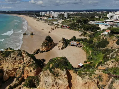 Trilho costeiro português com mar e vegetação mediterrânica