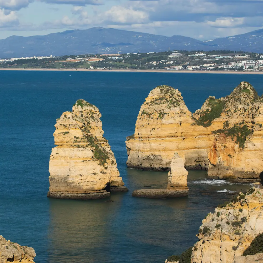 Costa portuguesa com falésias, mar atlântico e aldeia clara